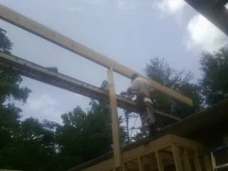Carpenter setting a ridge beam over a new addition frame — Ice Dam Removal by Roofing Brothers in Catasauqua