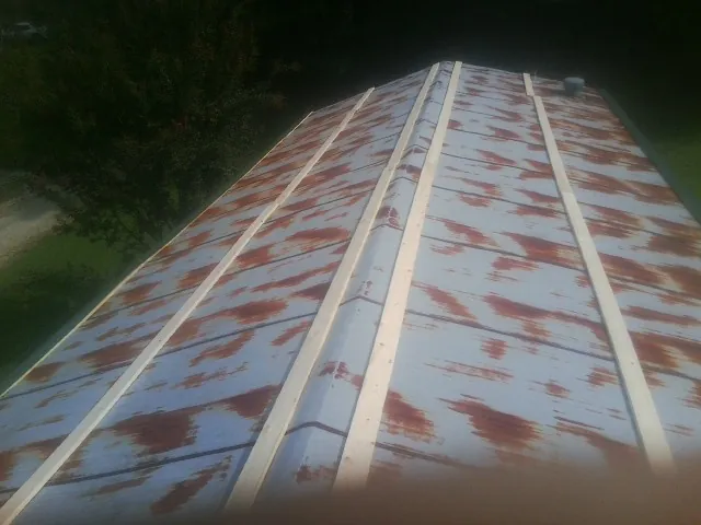 Rusted metal roof panels with new wood purlins before replacement — Storm Damage Roof Repair in Catasauqua by Roofing Brothers