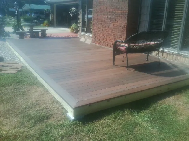 New wood deck and wicker chair beside a brick house in Catasauqua