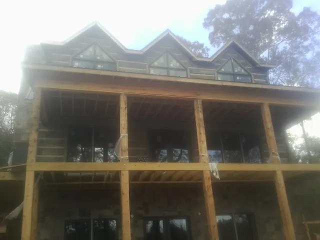 Dormers and porch framing on a large log home under construction — Roof Coating work by our crew in Catasauqua