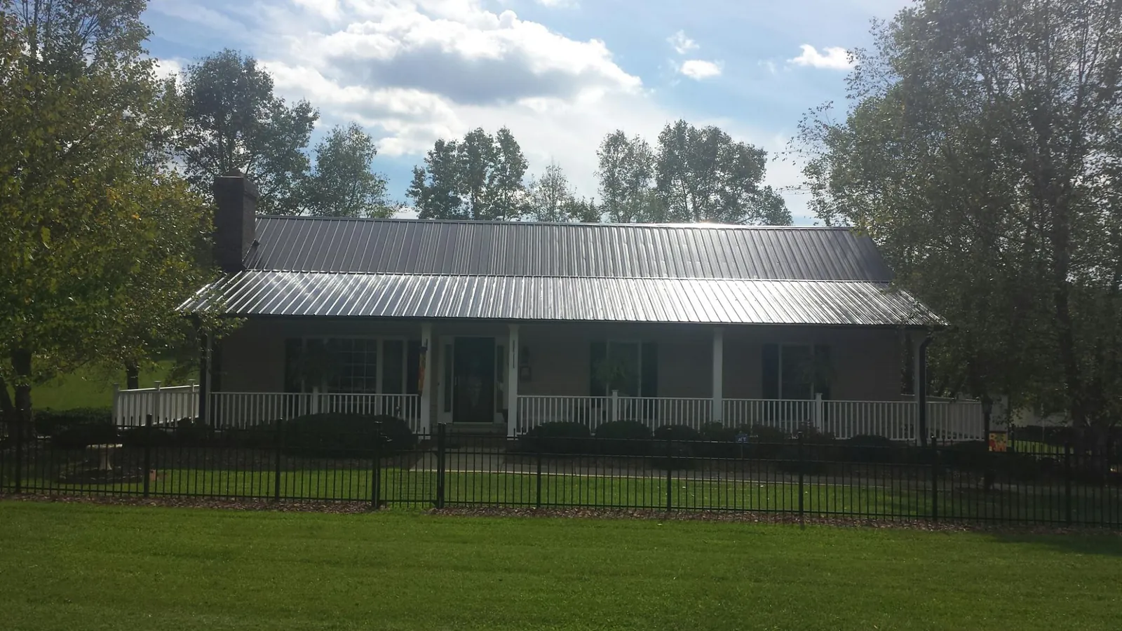 Gray metal roof on a brick ranch with a full width front porch — Gutter Guard Installation work by our crew in Catasauqua