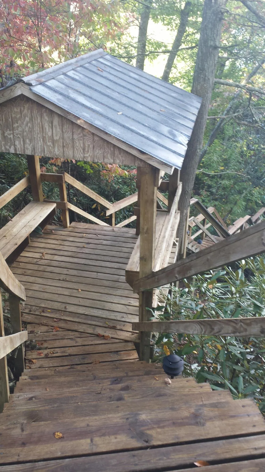 Metal roofed shelter over wooden steps on a wooded walkway — Skylight Repair & Installation work by our crew in Catasauqua